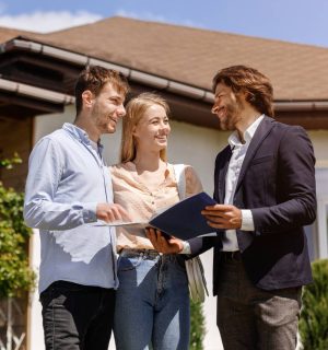 Real estate agent showing home rental or purchase contract to his customers in house backyard