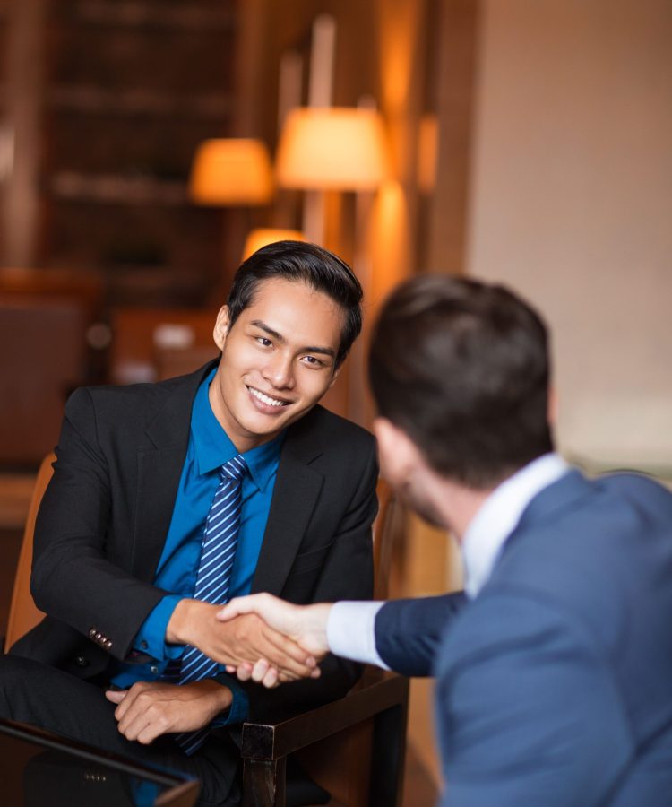 two-smiling-partners-shaking-hands-cafe (1)
